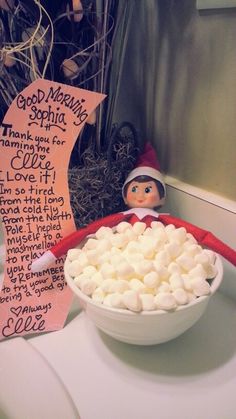 a bowl of marshmallows sitting on top of a counter next to a sign