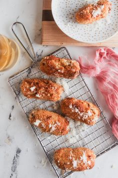 some fried food on a cooling rack next to a plate