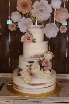 a three tiered wedding cake with pink and white flowers