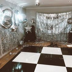 an empty party room with disco balls and silver curtained backdrops on the wall