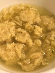 a white bowl filled with meatballs and noodles in broth, ready to be eaten