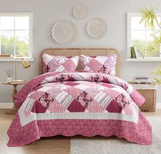 a bed with pink bedspread and pillows in a room