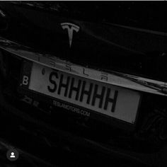 a close up of the license plate on a black car with it's logo