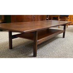 a wooden coffee table sitting on top of a carpeted floor