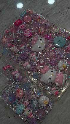 two plastic trays filled with hello kitty buttons