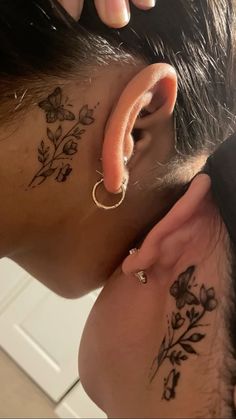 a person with tattoos on their ear and behind the ear is a small flower tattoo