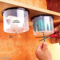 two plastic containers with yarn and scissors hanging from the ceiling next to each other on a wooden shelf