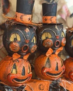 three pumpkins with faces painted on them are sitting next to each other in the shape of cats