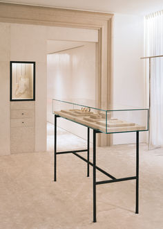 a glass table with two sinks on it in a room that has white walls and flooring