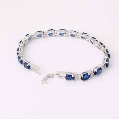 This stunning bracelet features 17 oval shaped Austrian Crystals in brilliant blue colors. Each stone is accented with two smaller crystals on each side creating the perfect contrast to the brightly colored stones. Deep, rich blue stones paired with vibrant, light catching cz diamonds create a luxurious piece for any occasion. Clasp closure for added security. Fit for royalty and a beauty for any occasion. Material: 14K White Gold Plated. Stones: 7mm x 5mm Austrian Cystal and 1.5 mm CZ Stones. S Blue Gemstone Bracelet In Cubic Zirconia, Blue Oval Tennis Bracelet For Formal Occasions, Blue Sapphire Oval Bracelets, Blue Oval Sapphire Tennis Bracelet, Blue Sapphire Oval Tennis Bracelet, Oval Blue Gemstone Bracelets, Blue Oval Bracelet For Anniversary, Blue Oval Bracelets For Anniversary, Oval Blue Jubilee Bracelet