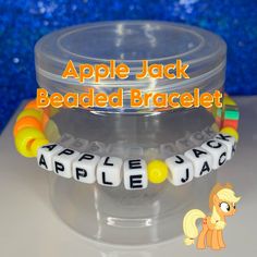 "This Apple Jack Beaded Bracelet is cute and a features the character from \"My Little Pony.\" This bracelet is handmade with love and creativity." Handmade Adjustable Novelty Name Bracelet, Handmade Playful Name Bracelet With Round Beads, Playful Handmade Name Bracelet With Round Beads, Playful Beaded Bracelets With Letter Beads For Crafting, Handmade Themed Beaded Bracelets For Birthday, Novelty Bracelets With Letter Beads, Handmade Novelty Beaded Bracelets For Birthday, Handmade Novelty Bracelets For Birthday, Handmade Novelty Beaded Bracelets For Birthdays