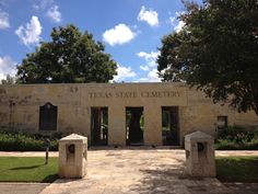 the texas state library is located in an old stone building with trees and bushes around it