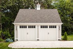 a white garage with two doors and windows