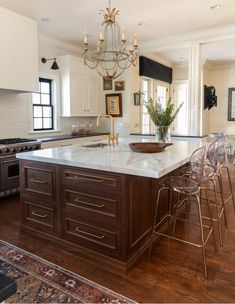 a large kitchen with an island in the middle and chairs at the counter top,