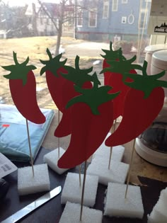 some red peppers are sitting on top of toothpicks in the shape of snow