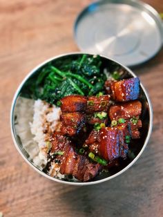 a bowl filled with meat and vegetables on top of rice