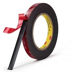 a roll of tape with a red ribbon on the side and a black stick sticking out of it