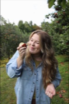 a woman holding an apple in her right hand