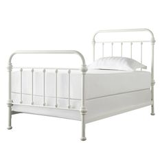 a white metal bed frame with two pillows on top of it and the headboard is turned down