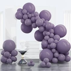 purple balloons floating in the air next to a hourglass