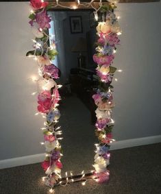 a mirror decorated with flowers and fairy lights