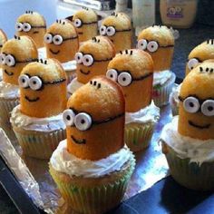 minion cupcakes with white frosting and googly eyes sitting on top of each other