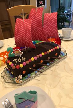 a cake shaped like a pirate ship on a table with plates and utensils