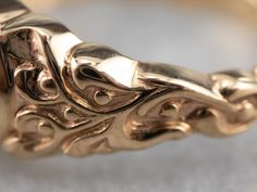 a close up view of a gold ring with filigrees and leaves on it