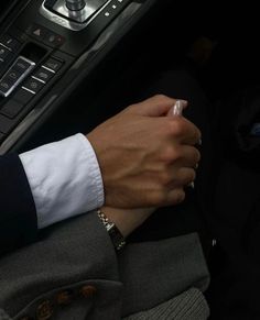 a person in a car holding the steering wheel handle and pressing buttons on their hand