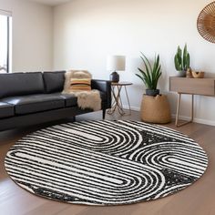 a living room with black leather couches and white rug