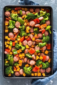 a pan filled with sausage, broccoli and peppers