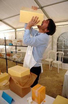 a man in a blue shirt and black pants holding a box over his head