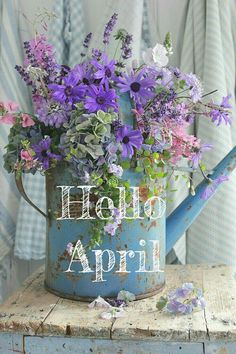 a blue watering can with purple flowers in it and the words hello april written on it