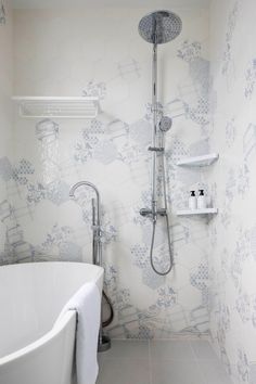 a white bath tub sitting next to a wall mounted shower faucet in a bathroom