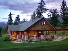 a log cabin is lit up in the evening