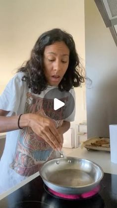 a woman is cooking in a pan on the stove