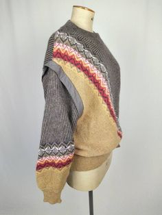 Stunning 80s vintage pattern knit warm women's sweater / jumper by Bogner. Diagonally striped / fair isle patterned in grey, mustard, beige, red, white. Featuring dropped shoulders, stud button shoulder, batwing sleeves. Made in West Germany. SIZE TAG: D42 FABRIC CONTENT: 30% wool 25% mohair 25% polyamide 20% alpaca CONDITION: excellent, no flaws to note. MEASUREMENTS (taken flat, not doubled): Bust: 57 cm / 22 1/2" Hem: 42 cm / 16 1/2" Length: 67 cm / 26 1/2" Please do not hesitate to contact me if you have any questions. Winter Brown Tops With Fair Isle Pattern, Winter Fair Isle Pattern Brown Tops, Brown Fair Isle Winter Top, Nordic Knit Sweater For Fall, Retro Cable Knit Sweater For Fall, Oversized Fair Isle Crew Neck Sweater, Nordic Multicolor Sweater For Fall, Multicolor Nordic Sweater For Fall, Retro Fair Isle Pattern Winter Tops