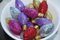 a white bowl filled with glitter covered christmas ornaments