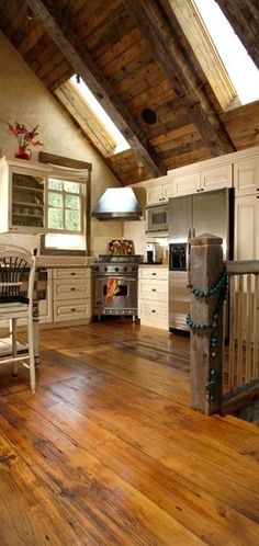 a kitchen with wooden floors and white cabinets