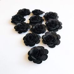 a bunch of black flowers sitting on top of a white table