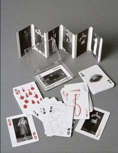 several playing cards are laying on the floor with pictures in front of them and one is missing