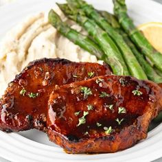 grilled pork chops, mashed potatoes and asparagus on a white plate