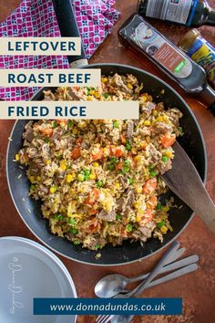 a bowl filled with rice and vegetables on top of a table next to silverware