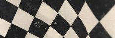 a black and white checkered fabric with small dots on it's edges is seen in close up