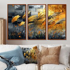 three paintings hanging on the wall in a living room with white couches and pillows