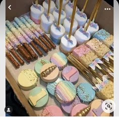 an assortment of decorated cookies and pastries on a table with gold utensils