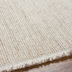 a close up view of a rug on a wooden floor with the end of an area rug