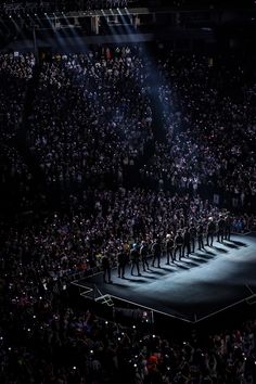 a large group of people standing on top of a stage in front of a crowd