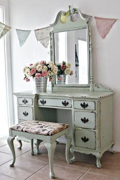 an old dresser with flowers and a mirror