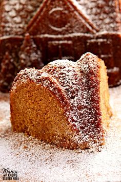 a cake with powdered sugar on top is cut into pieces and sits on a white surface